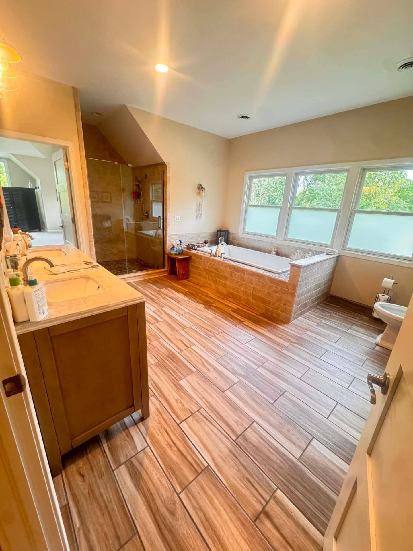 Freshly cleaned primary bathroom with soaking tub and walk-in shower